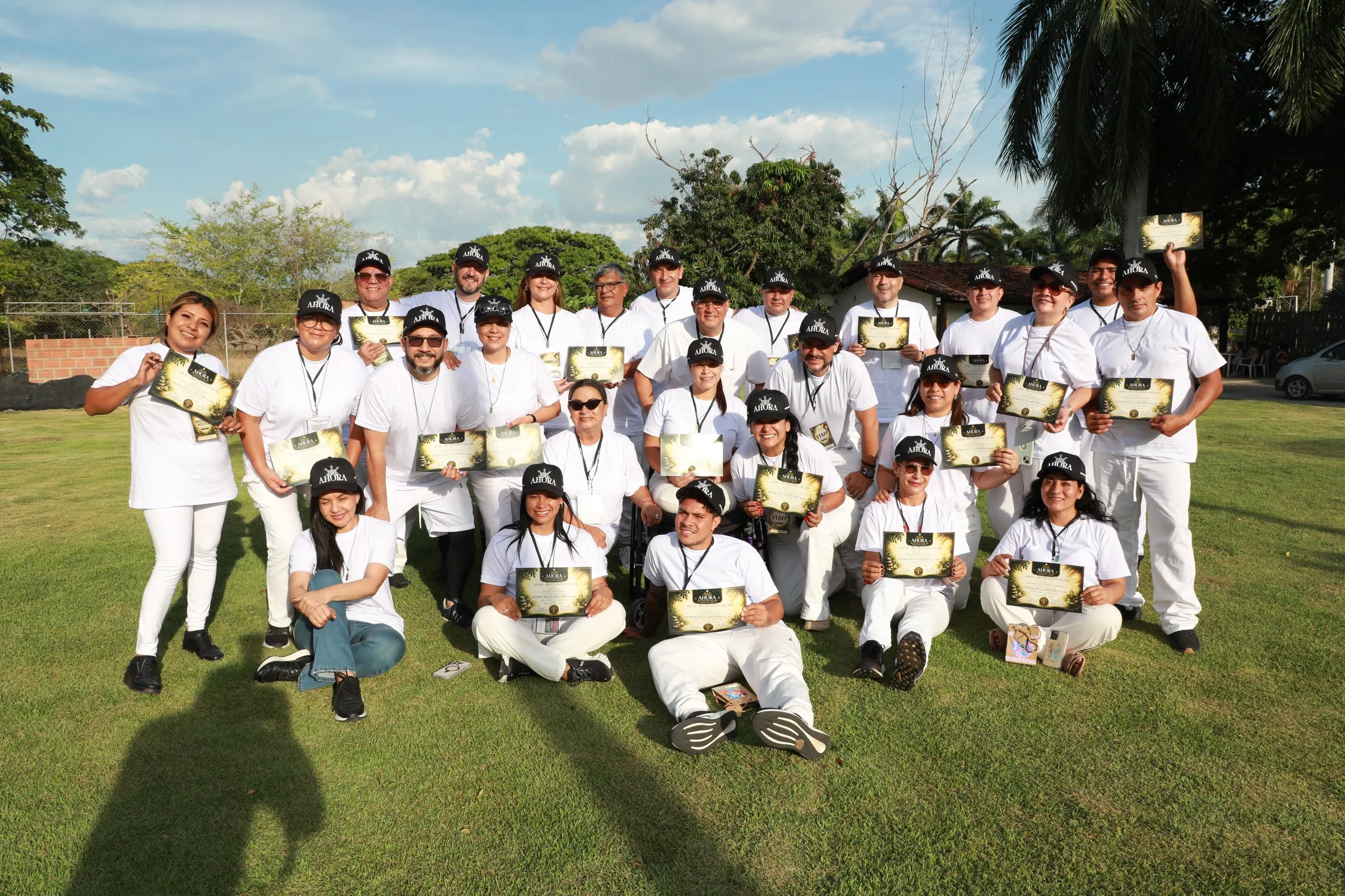 Grupo de personas con camisetas blancas reunidas en el taller Detrás de la adicción